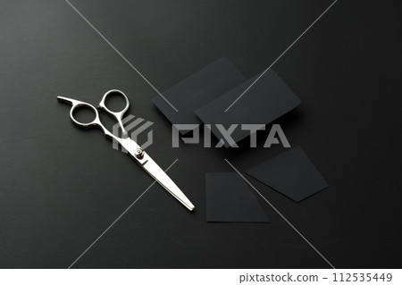 Hairdressing scissors and businesscard mock up on black background Hairdressing scissors and businesscard mock up on black background 112535449