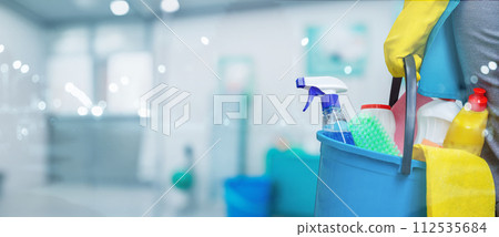 Cleaning woman holding a bucket of cleaning products. 112535684