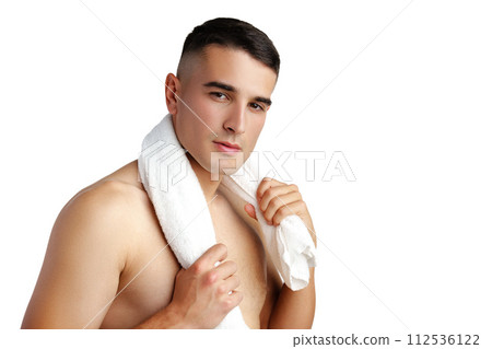 Young smiling man with towel on shoulders posing at camera on white background Young smiling man with towel on shoulders posing at camera on white background 112536122