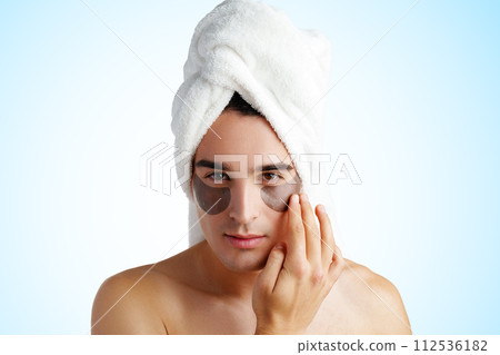 Portrait of attractive young male model with eye patches on white background Portrait of attractive young male model with eye patches on white background 112536182