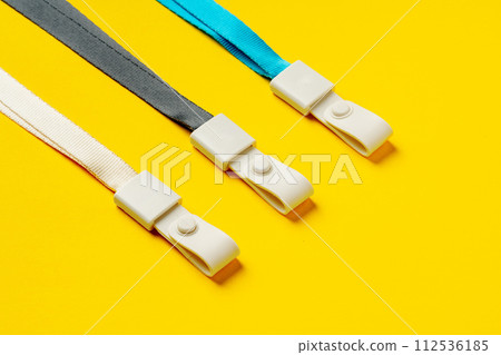 Badge strings on yellow background close up Badge strings on yellow background close up 112536185