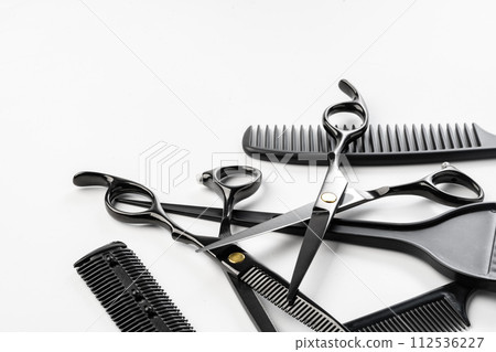Black hairdressing tools and various hairbrushes on white background 112536227