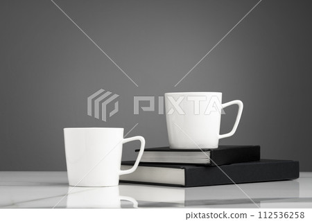 Ceramic cups on marble table against gray background 112536258