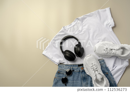 White T-shirt, jeans and sneakers on beige background White T-shirt, jeans and sneakers on beige background 112536273