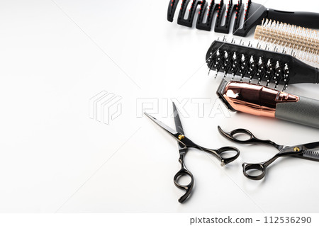 Black hairdressing tools and various hairbrushes on white background Black hairdressing tools and various hairbrushes on white background 112536290