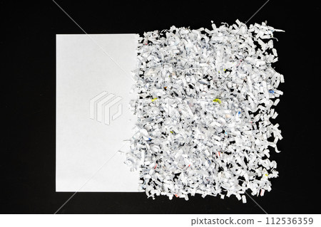 Shredded white paper on black background close up 112536359