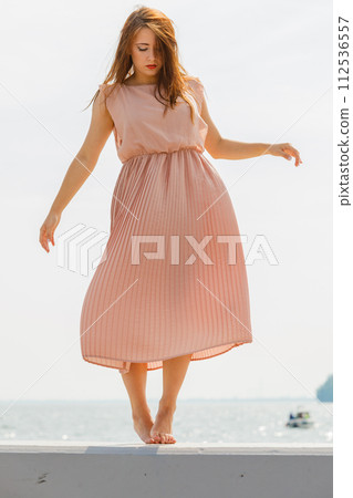 Woman dancing wearing long light pink dress 112536557