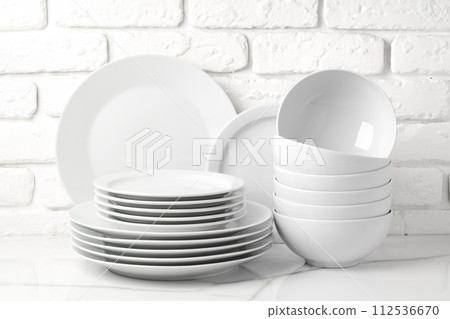 Set of dishes on table against brick wall background 112536670