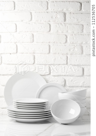 Set of dishes on table against brick wall background 112536705