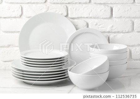 Set of dishes on table against brick wall background 112536735