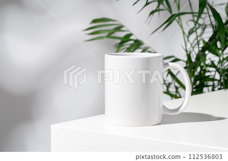 Porcelain cup and palm branch on white background 112536803