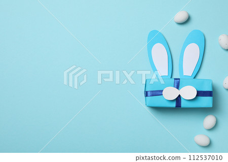 Blue gift box with bunny ears on a blue background 112537010
