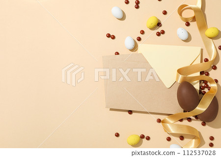 Chocolate eggs with a paper envelope on a light background 112537028