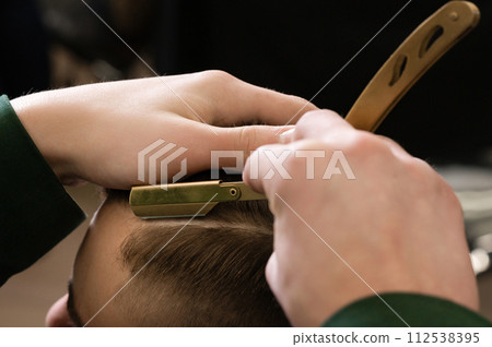 The barber makes the outline with a dangerous razor the undercut haircut 112538395