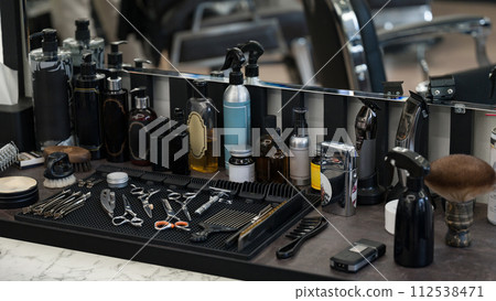 Barbers tools for mens haircuts laid out on a table. Men's hair and beard care products. Barbers tools for mens haircuts laid out on a table. Men's hair and beard care products. 112538471