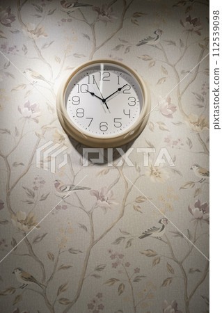 A round clock on the wall indicates the exact time. decor in the room A round clock on the wall indicates the exact time. decor in the room 112539098