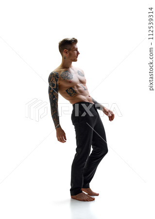 Young handsome man with tattoos on body posing demonstrating his athletic body against white studio background. Copy space. Young handsome man with tattoos on body posing demonstrating his athletic body against white studio background. Copy space. 112539314