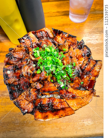 A plate of bacon and onions sits on a wooden table A plate of bacon and onions sits on a wooden table 112539735