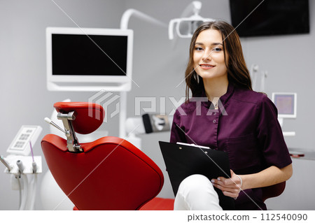 Doctor dentist working in office, using clipboard and making notes Doctor dentist working in office, using clipboard and making notes 112540090