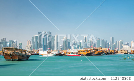 A panoramic view of the old dhow harbour timelapse in Doha, Qatar, with the West Bay skyline in the background. A panoramic view of the old dhow harbour timelapse in Doha, Qatar, with the West Bay skyline in the background. 112540568