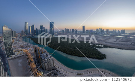 Buildings on Al Reem island in Abu Dhabi day to night timelapse from above. Buildings on Al Reem island in Abu Dhabi day to night timelapse from above. 112540673