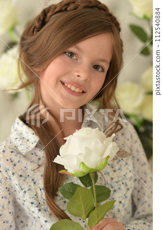 Pretty little girl smiling and posing with flowers Pretty little girl smiling and posing with flowers 112540884