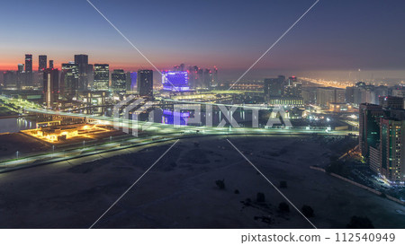 Abu Dhabi city skyline with skyscrapers before sunrise from above night to day timelapse Abu Dhabi city skyline with skyscrapers before sunrise from above night to day timelapse 112540949