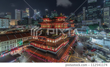 The Buddha Tooth Relic Temple comes alive at night timelapse in Singapore Chinatown, with the city skyline in the background. The Buddha Tooth Relic Temple comes alive at night timelapse in Singapore Chinatown, with the city skyline in the background. 112541174