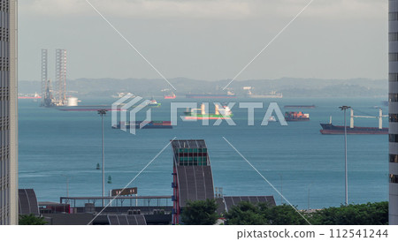 Various cargo ships waiting to load and unload in the harbour near the busiest port of Singapore aerial timelapse Various cargo ships waiting to load and unload in the harbour near the busiest port of Singapore aerial timelapse 112541244