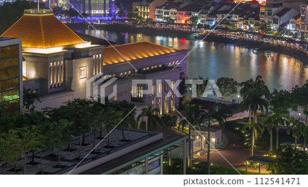 Parliament House in downtown Singapore aerial night timelapse and boat quay in the background. 112541471