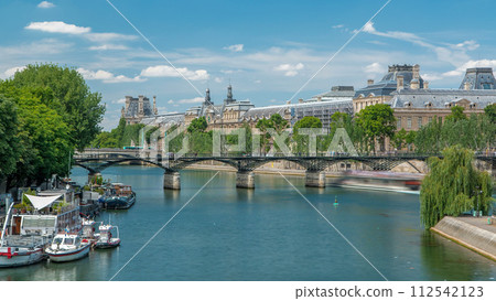 Touristic boat passes below Pont des Arts, on boat station on Seine river timelapse in Paris. Touristic boat passes below Pont des Arts, on boat station on Seine river timelapse in Paris. 112542123