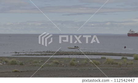 Waterskiing Near Shore Stirring Up Birds in Magellan Strait 112542447