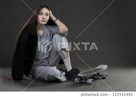 Beautiful girl model with a skateboard in a photo studio. 112542495
