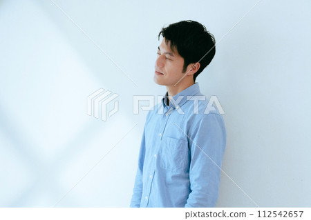 A man standing against a white wall A man standing against a white wall 112542657