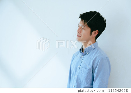 一個人靠著白牆站立 112542658