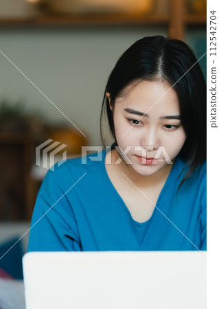 A woman troubled watching a personal computer A woman troubled watching a personal computer 112542704