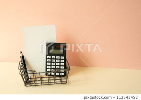 Consumer shopping basket with calculator, pencil, memo pad on ivory and pink background. Economic Concept 112543458
