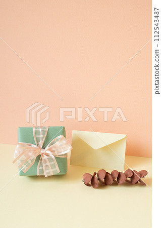 Green gift box, envelope, eucalyptus leaf on ivory table. pink wall background 112543487