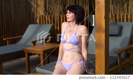 A 40-year-old woman sunbathes at a resort A 40-year-old woman sunbathes at a resort 112545027