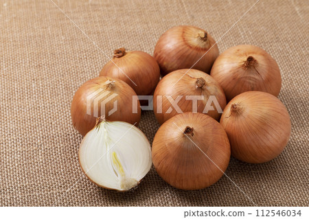 Onions arranged on linen cloth 112546034