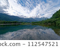 Blue pond and dramatic blue sky with clouds 112547521