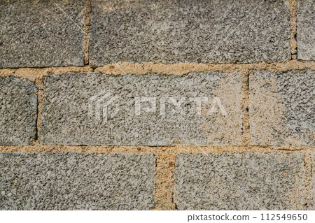 Textured wall of building blocks with a thick layer of mortar between the rows, so in some places there are traces of erased excess mortar, Simple construction techniques Textured wall of building blocks with a thick layer of mortar between the rows, so in some places there are traces of erased excess mortar, Simple construction techniques 112549650