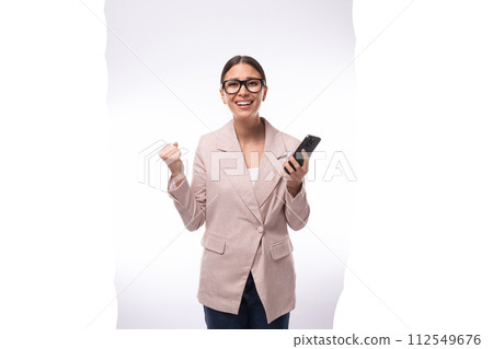 pretty smart young woman with black hair and glasses for vision dressed in a beige jacket and jeans 112549676