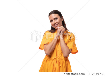 european friendly smiling young woman with black hair is dressed in an orange summer dress on 112549739