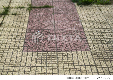Textured surface of paving slabs running along lines, between which certain drawings are drawn. Theme of overcoming life path in which person observes various situations and gains experience Textured surface of paving slabs running along lines, between which certain drawings are drawn. Theme of overcoming life path in which person observes various situations and gains experience 112549799