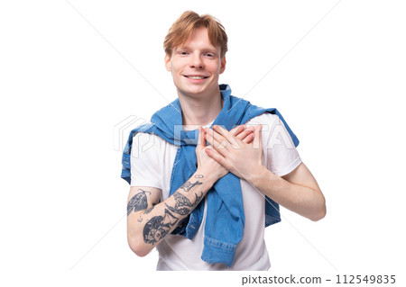 portrait of a young stylish fashionable european man with red hair and a tattoo on his arms on a 112549835