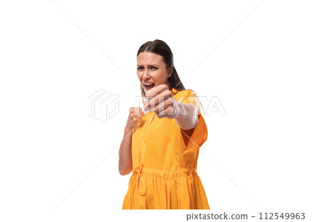 young caucasian brunette woman with long hair dressed in a yellow summer dress pulls her hand into 112549963