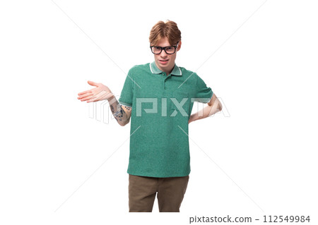 portrait of a young smart red-haired guy in a green t-shirt having critical thinking 112549984