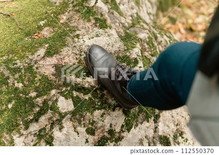 women's feet in leather autumn boots and jeans stand on the green forest moss women's feet in leather autumn boots and jeans stand on the green forest moss 112550370