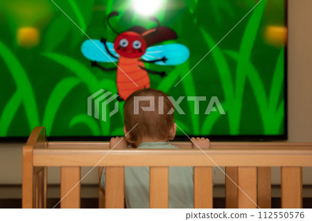 Cartoons on the TV screen that a small child watches from a crib Cartoons on the TV screen that a small child watches from a crib 112550576